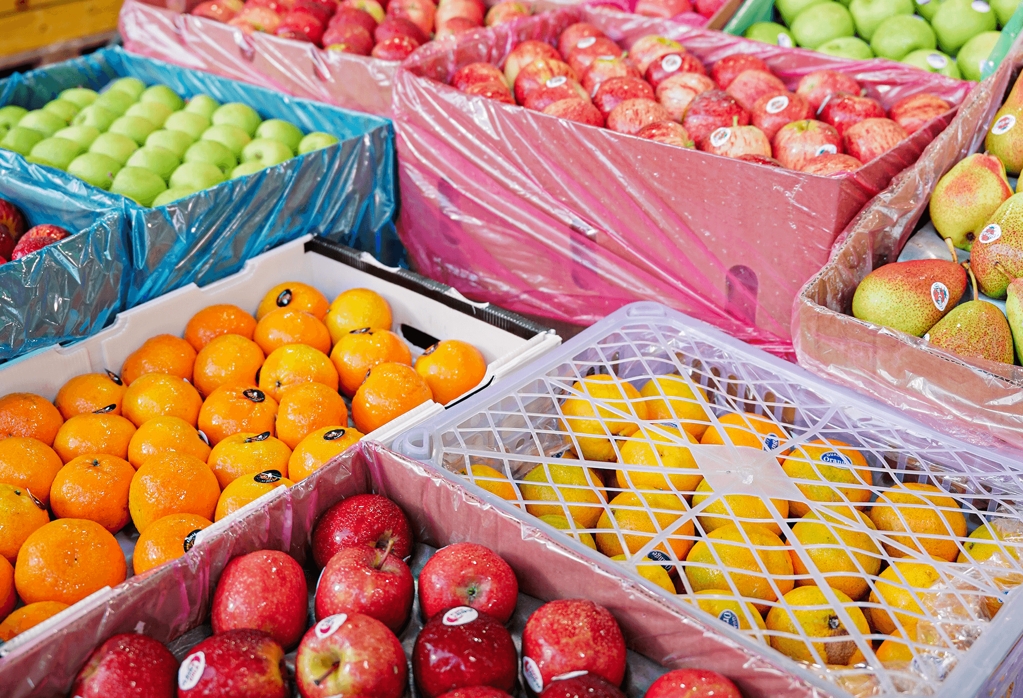 Crates of fresh apples, oranges and pears packed for commercial fruit supply