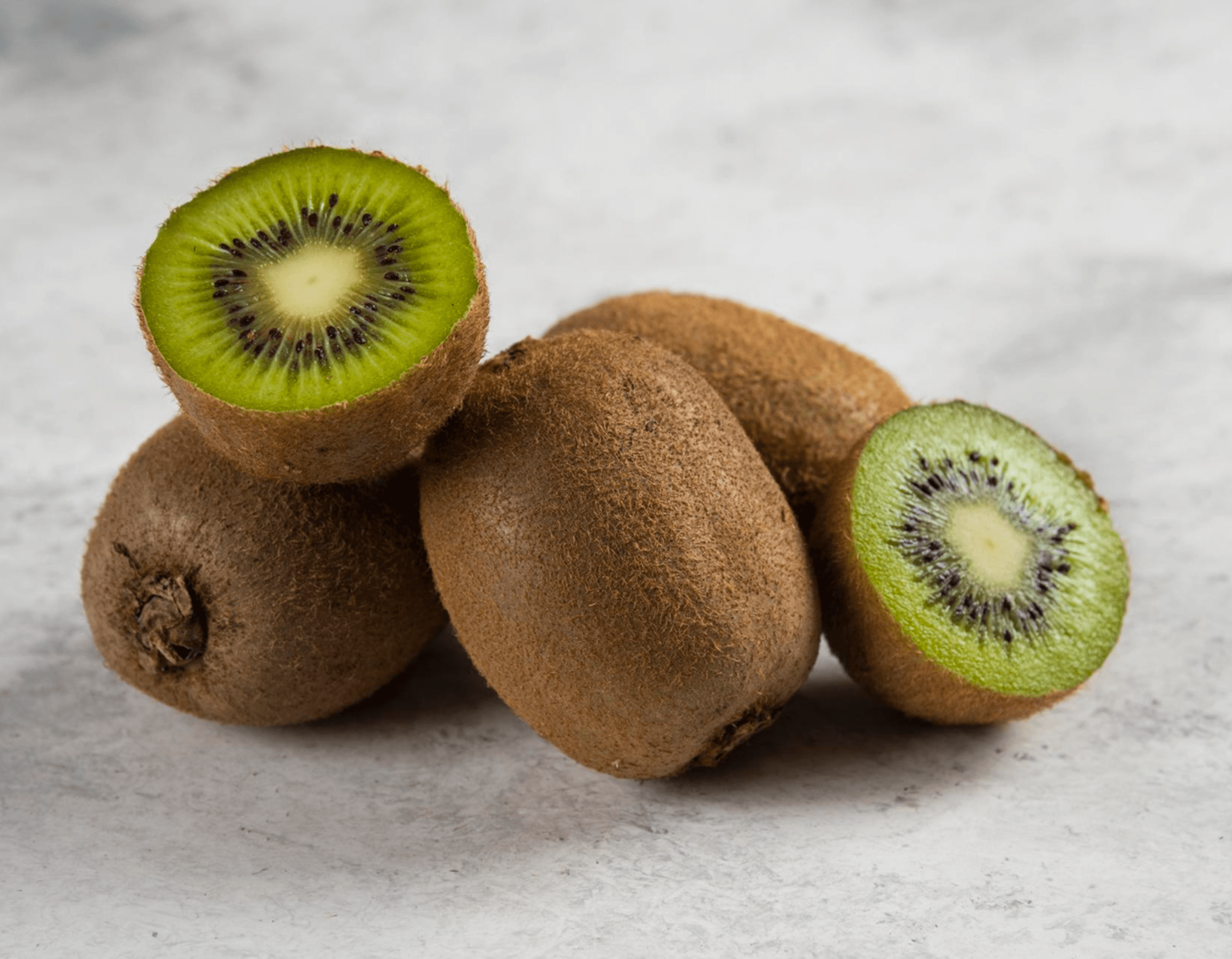 Fresh kiwi fruit whole and halved to show quality and ripeness