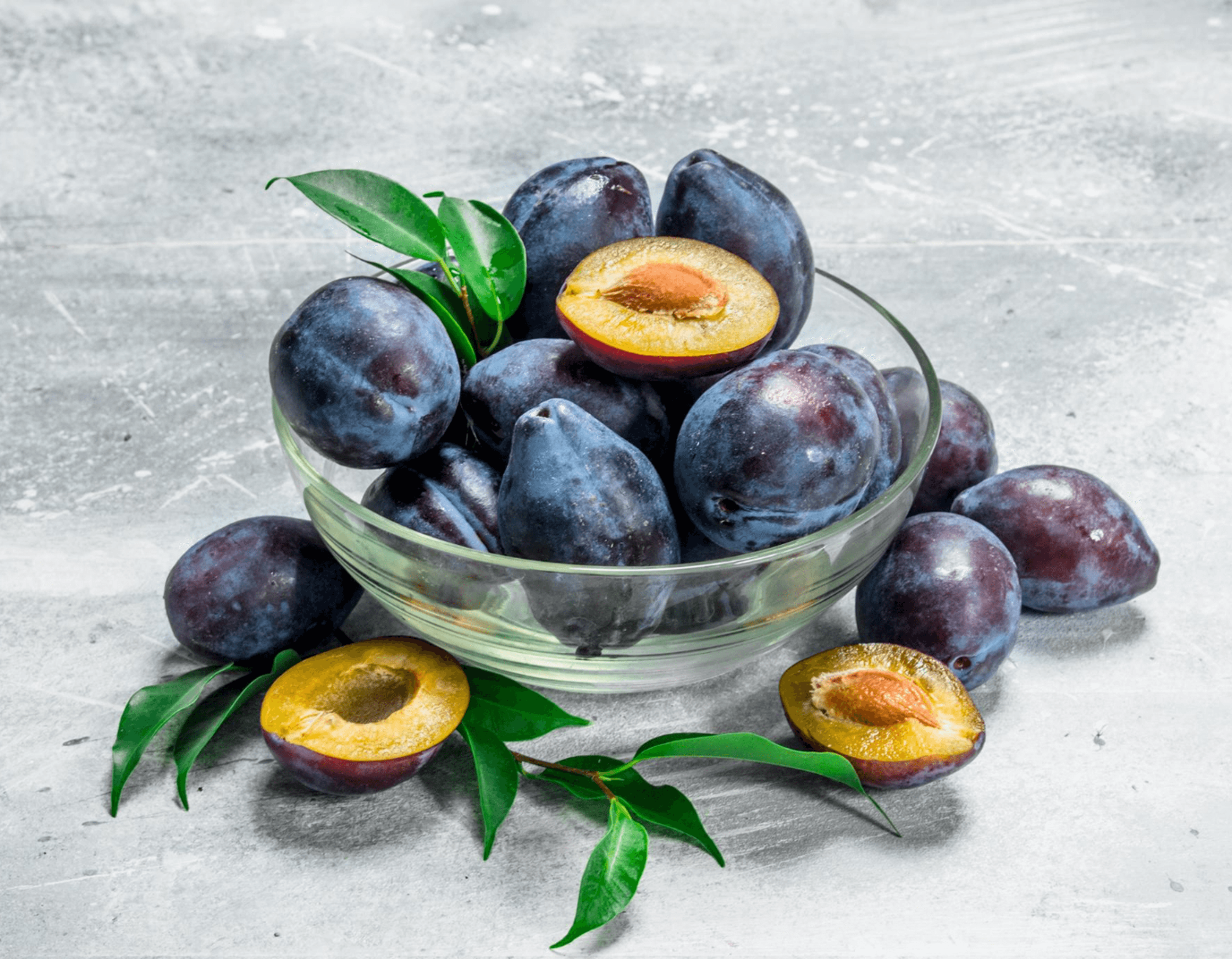 Fresh plums in a glass bowl for seasonal commercial supply