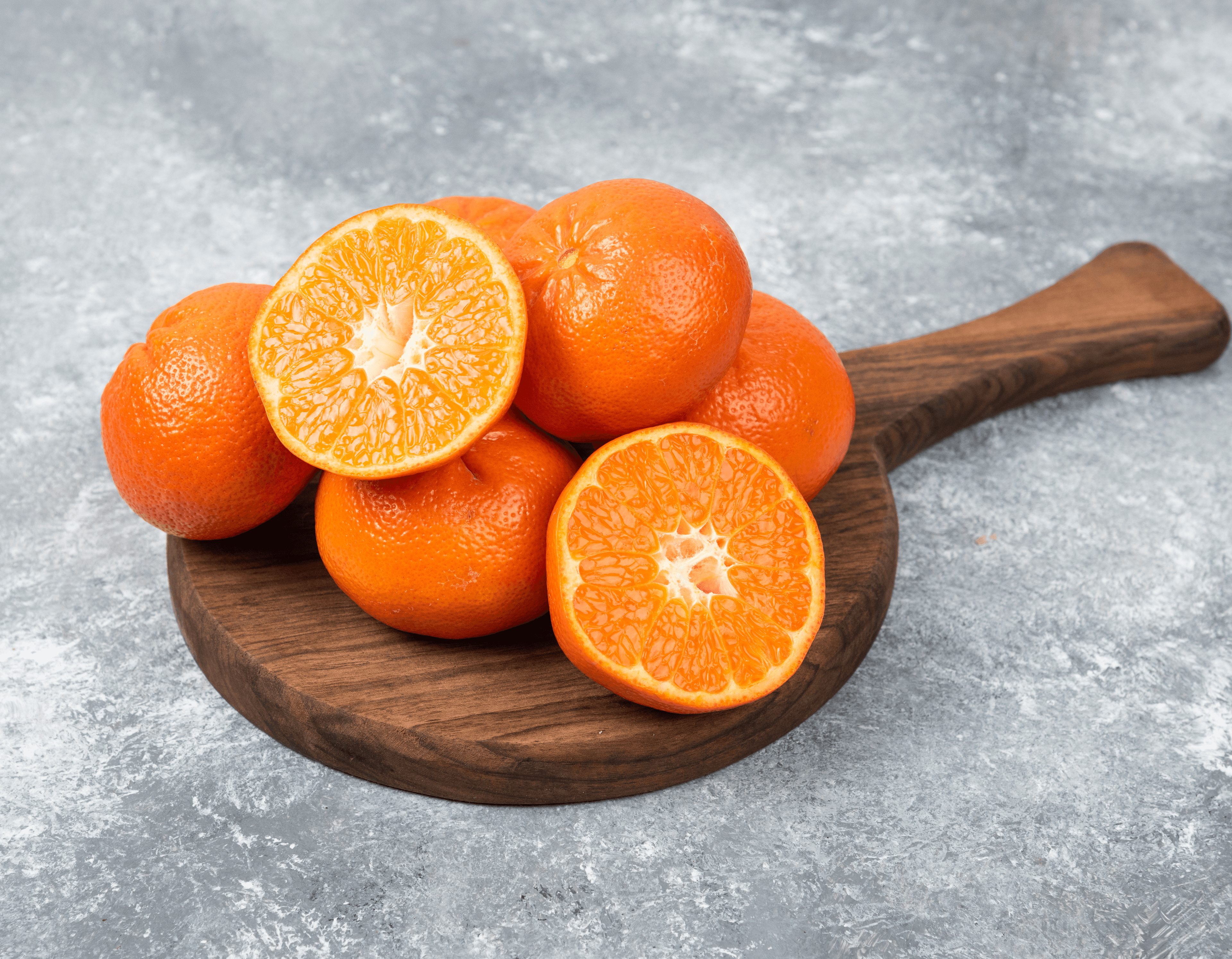 Fresh oranges and mandarins whole and halved on a wooden board